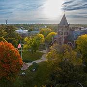 Campus overhead in the fall with bright sun peeking through the clouds